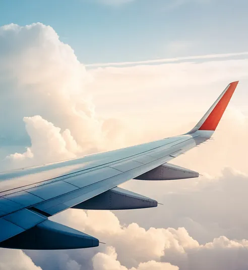 Airplane wing flying over clouds