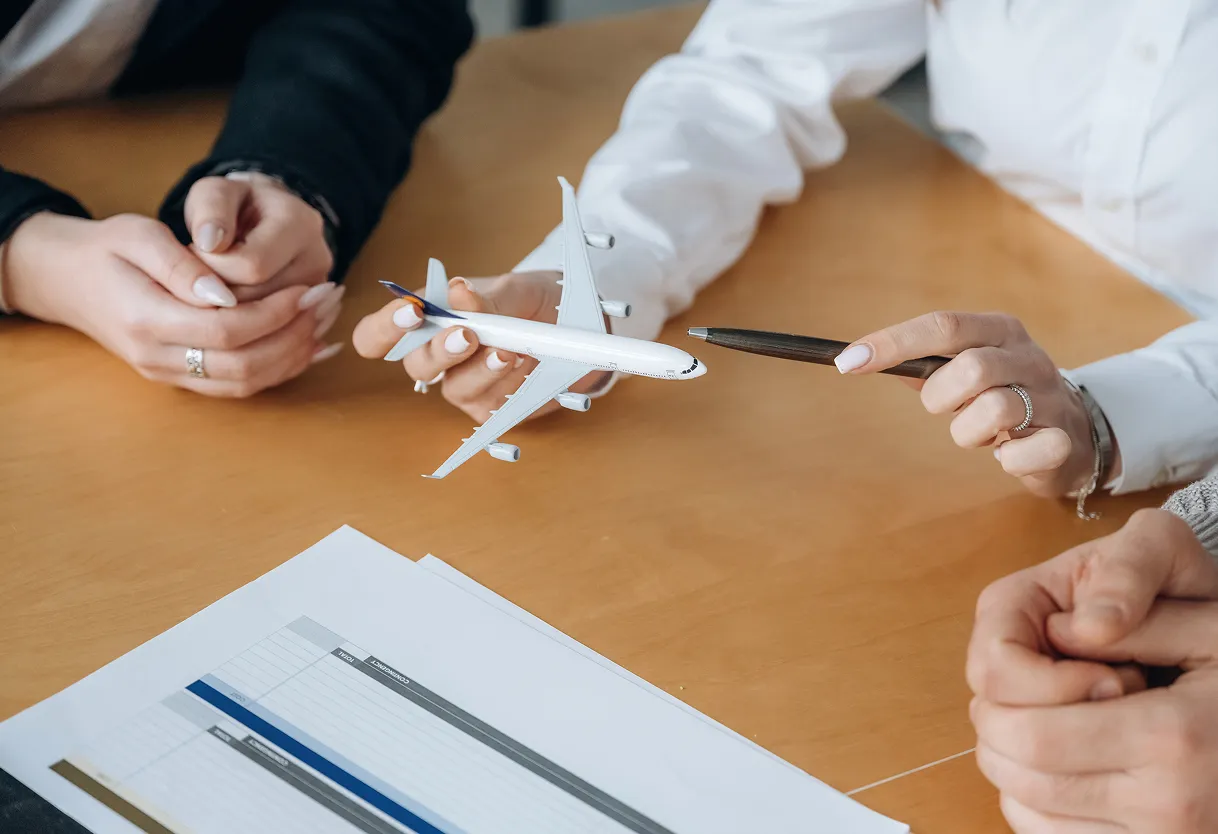 Hands holding a model airplane over a desk